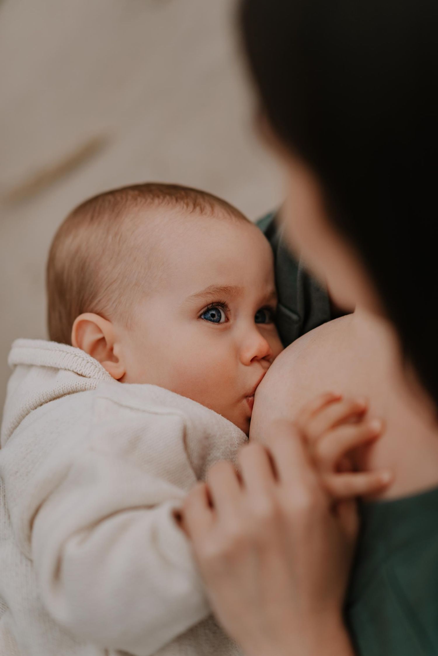 Intimate close-up nursing moment captured in soft natural light.
