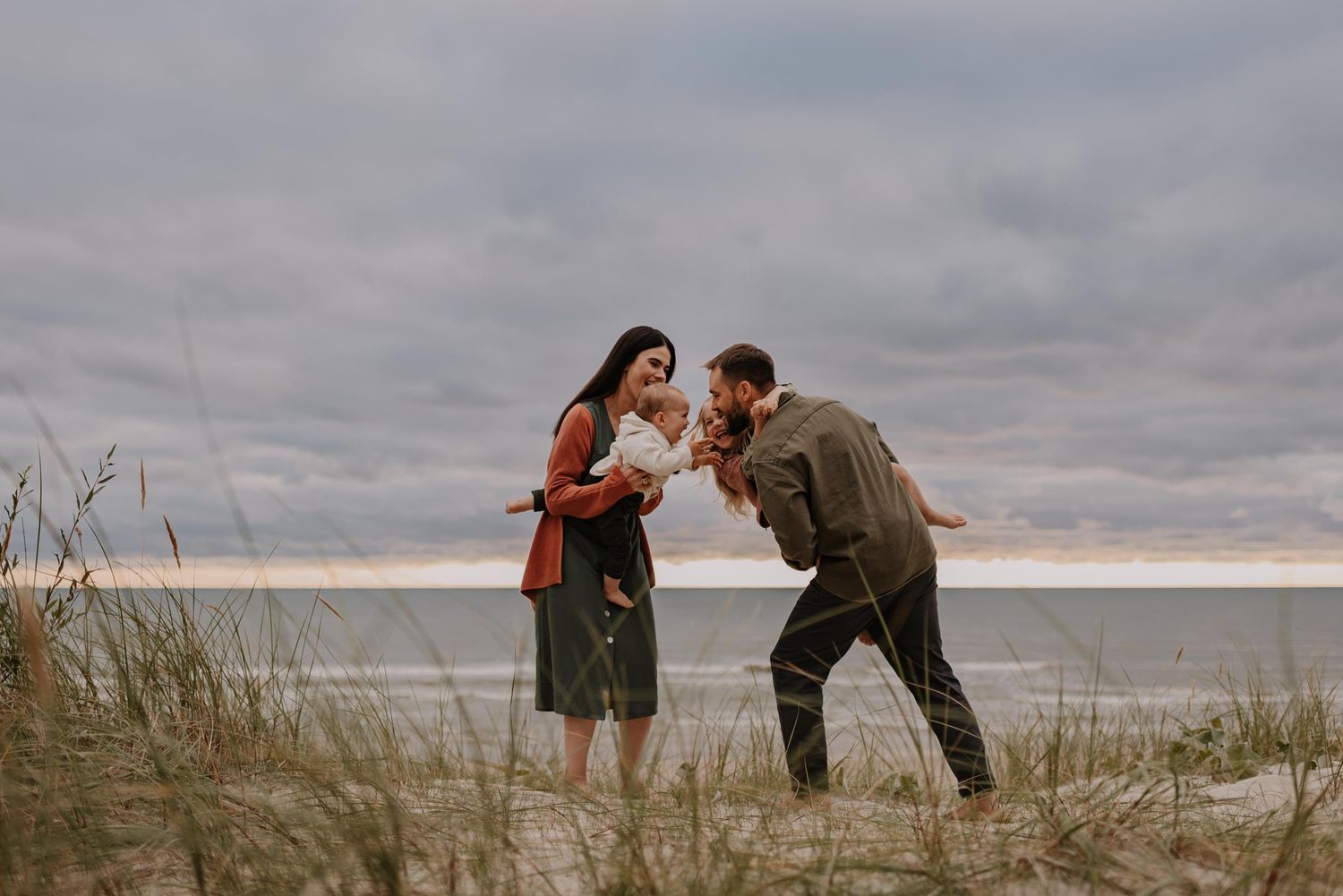 Family spending quality time together on sandy beach during golden hour.
