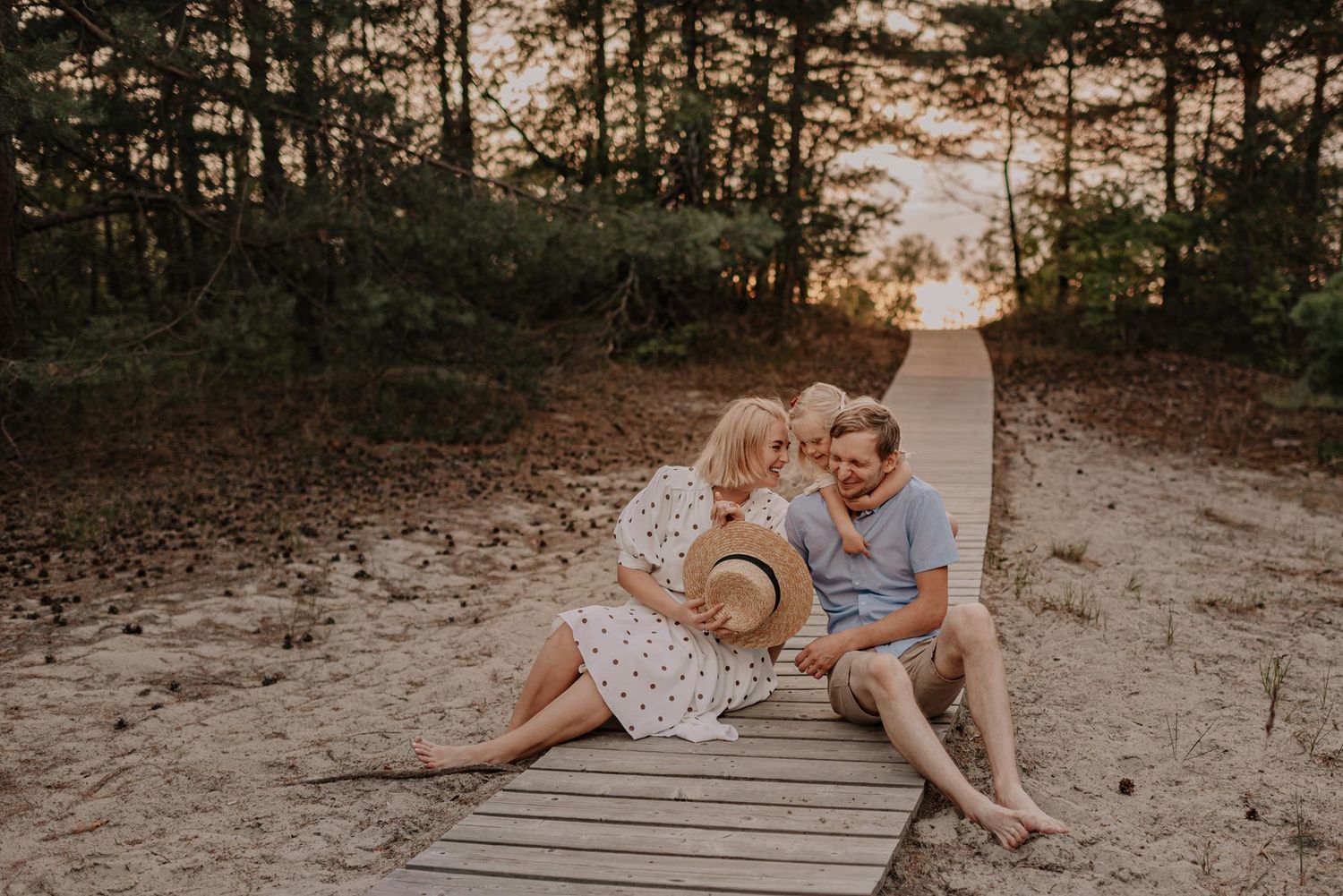 Romantic forest photoshoot among tall pine trees at golden hour.