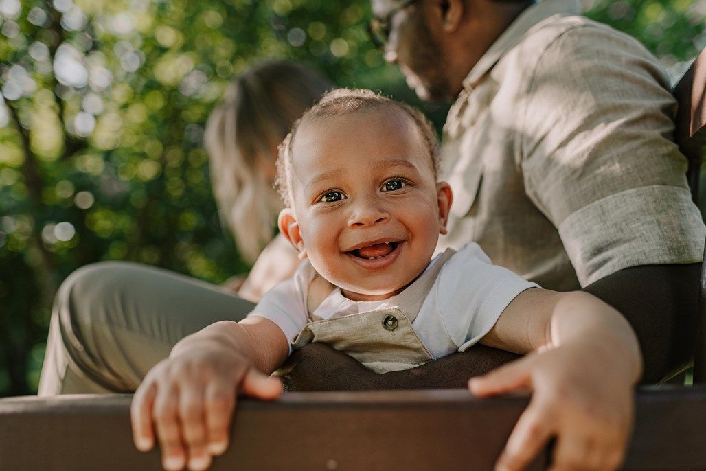 Joyful expressions and laughter during an outdoor family photoshoot.