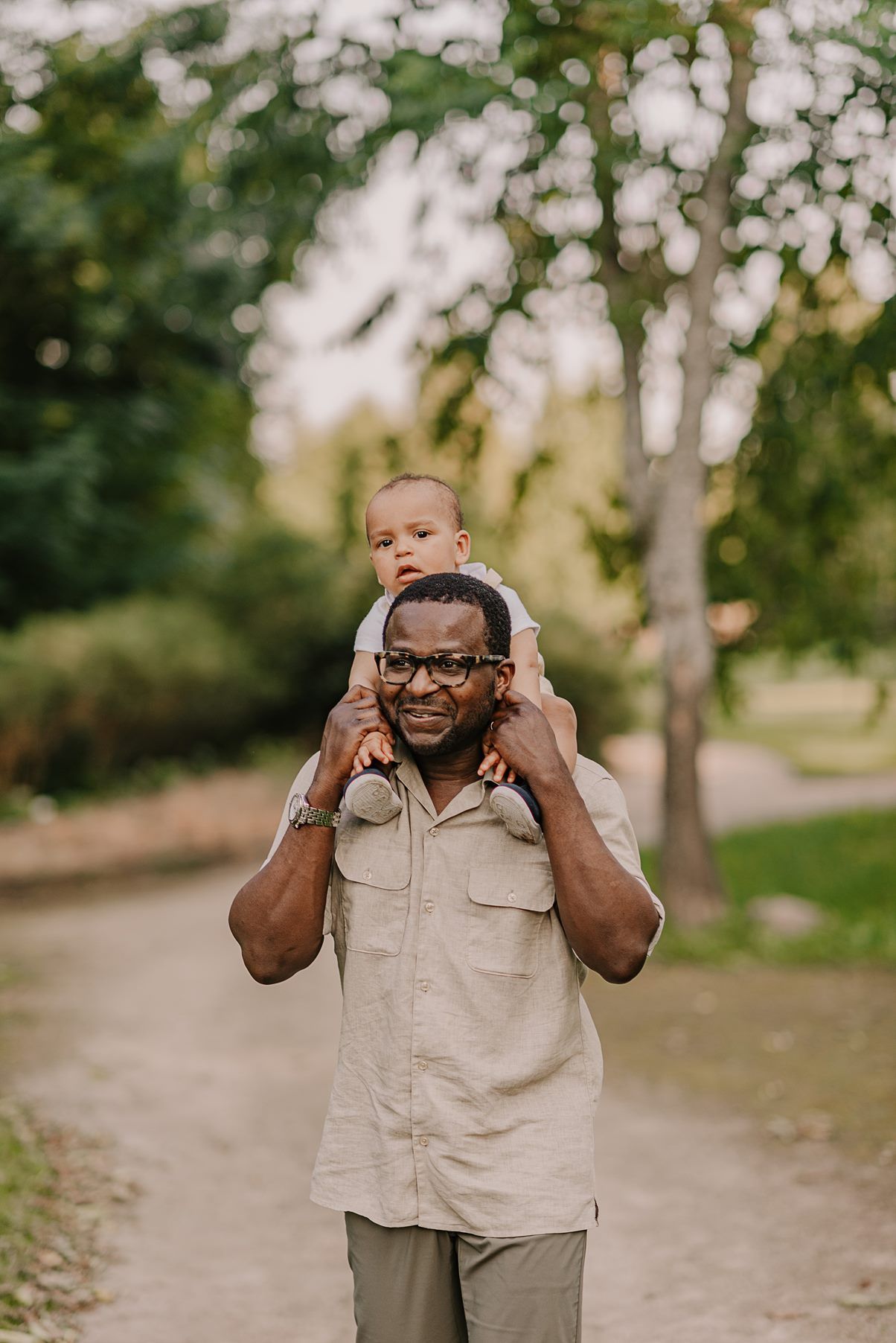 Playful interactions between family members in a sun-dappled outdoor setting.