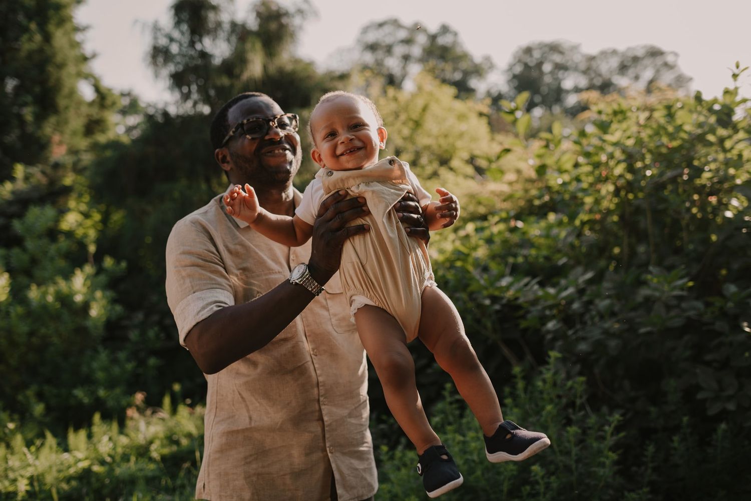 Family sharing tender moments during golden hour in a garden setting.