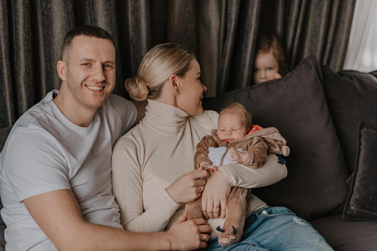 Family bonding together on couch during lifestyle photo session.