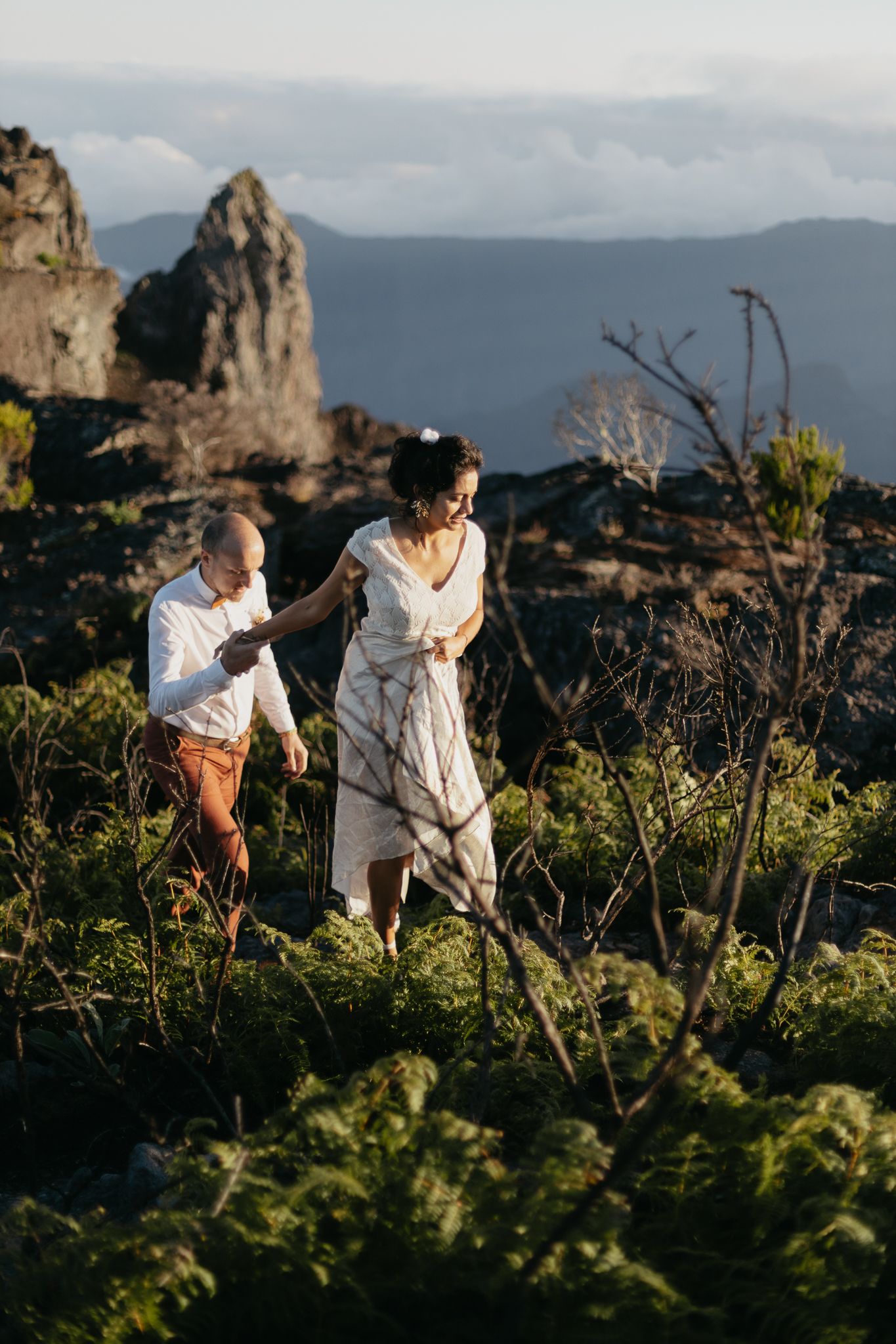 Photographe capturant un couple marchant sur un sentier de montagne