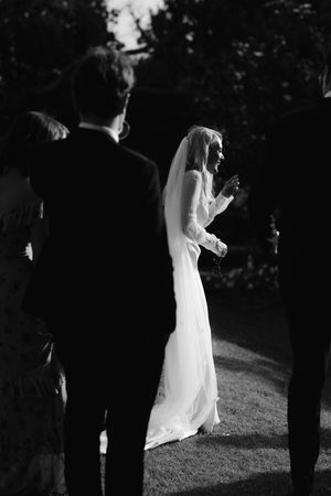 A black and white photo sequence captures a bride in a white dress dancing in a garden setting.