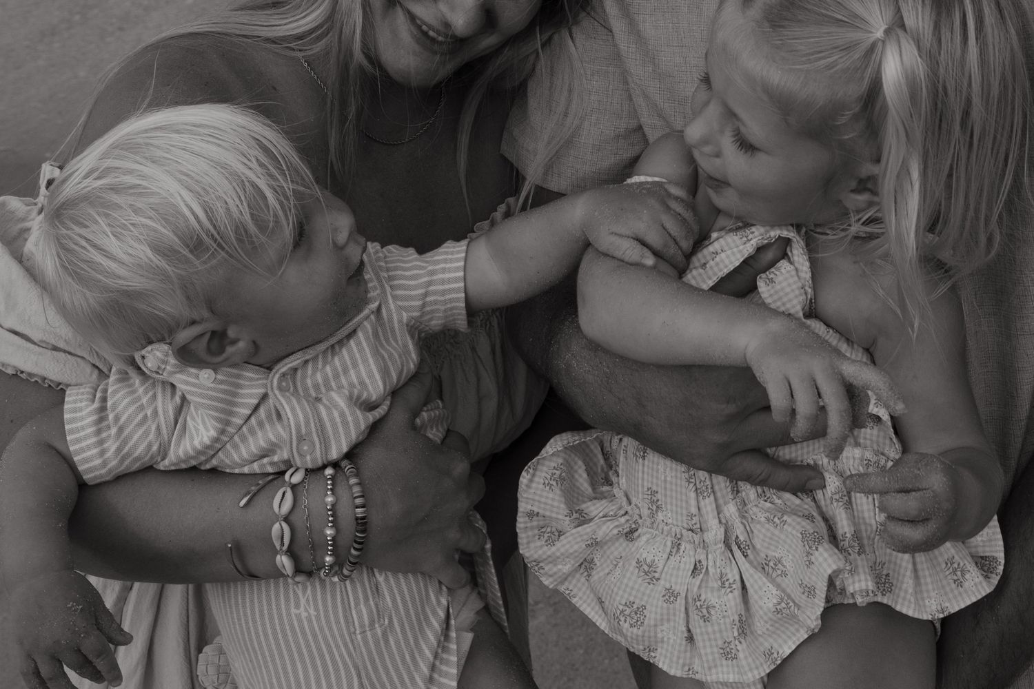 A series of black and white photographs showing tender moments between parents and their young children.
