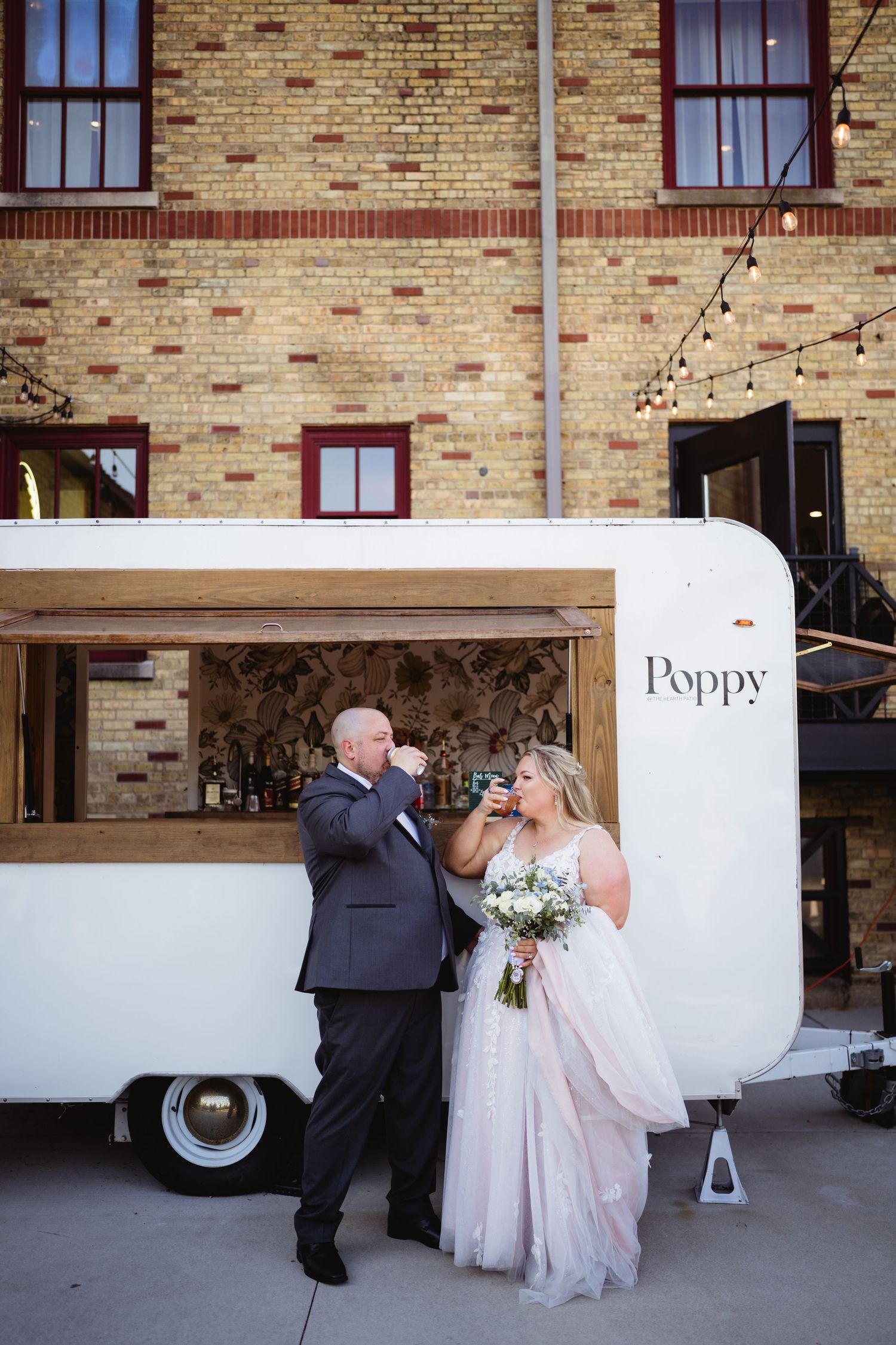 A wedding sequence showing a couple walking together against a rustic brick wall backdrop.