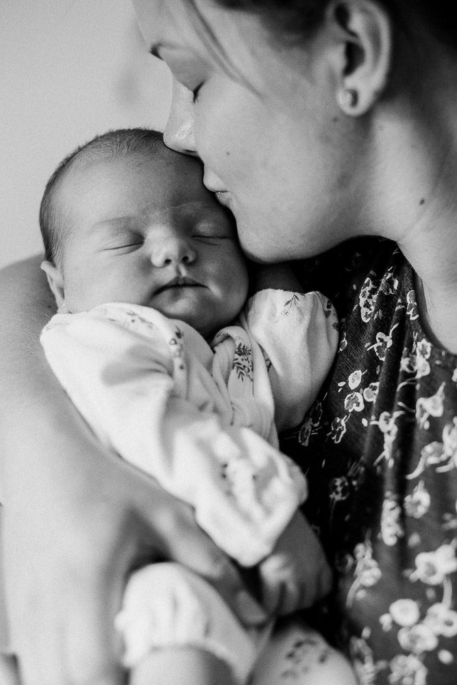Intimate black and white newborn photography series showing tender moments.