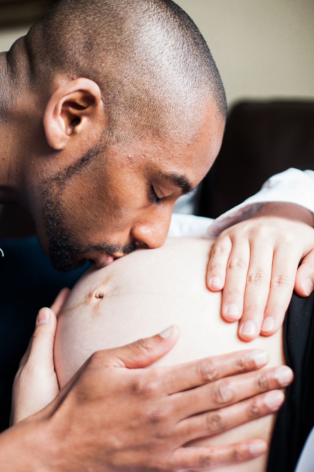 A series of intimate close-up shots showing gentle hands cradling and embracing a pregnant belly.