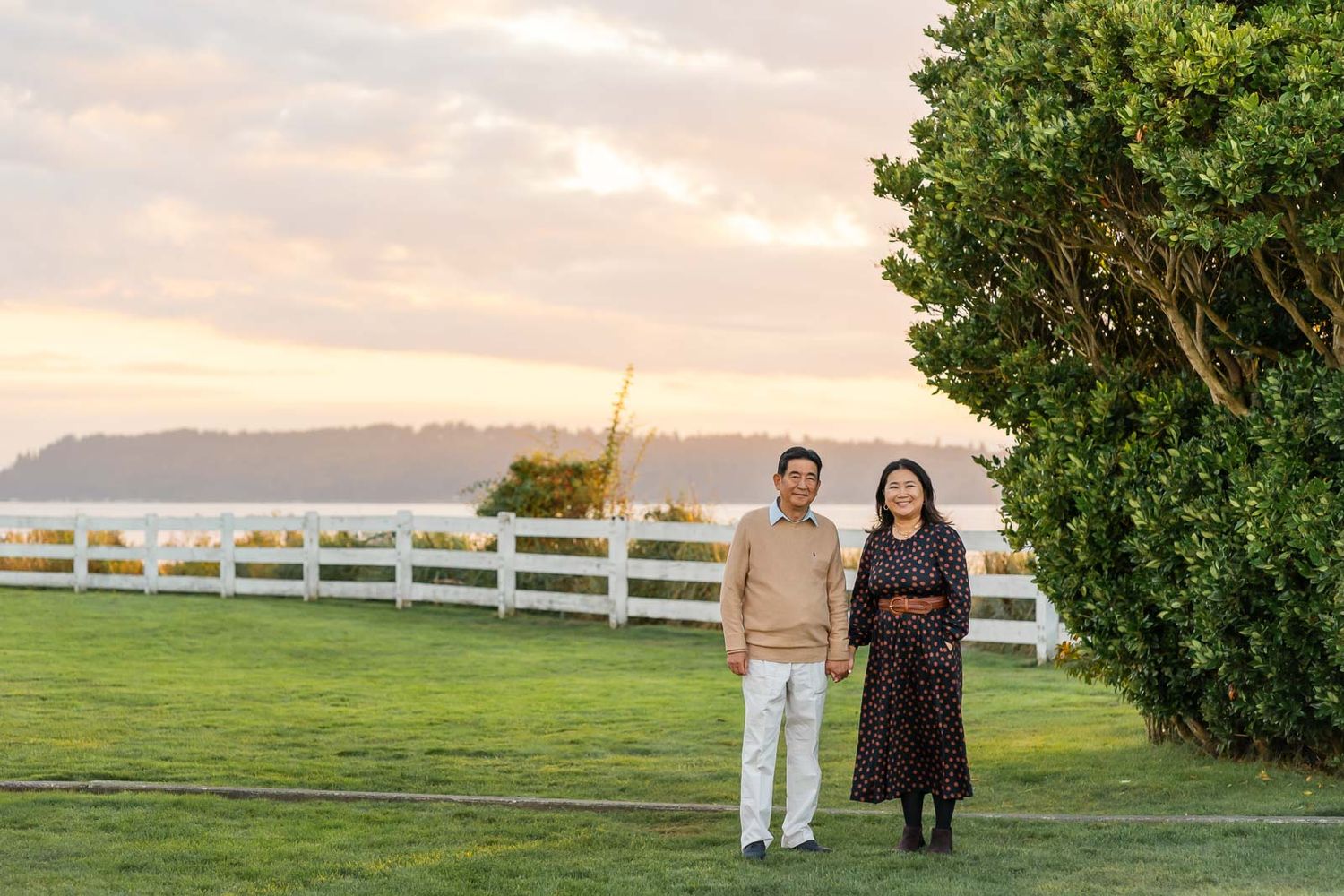 Father and daughter poses for portrait at sunset in Mukilteo lighthouse park.
