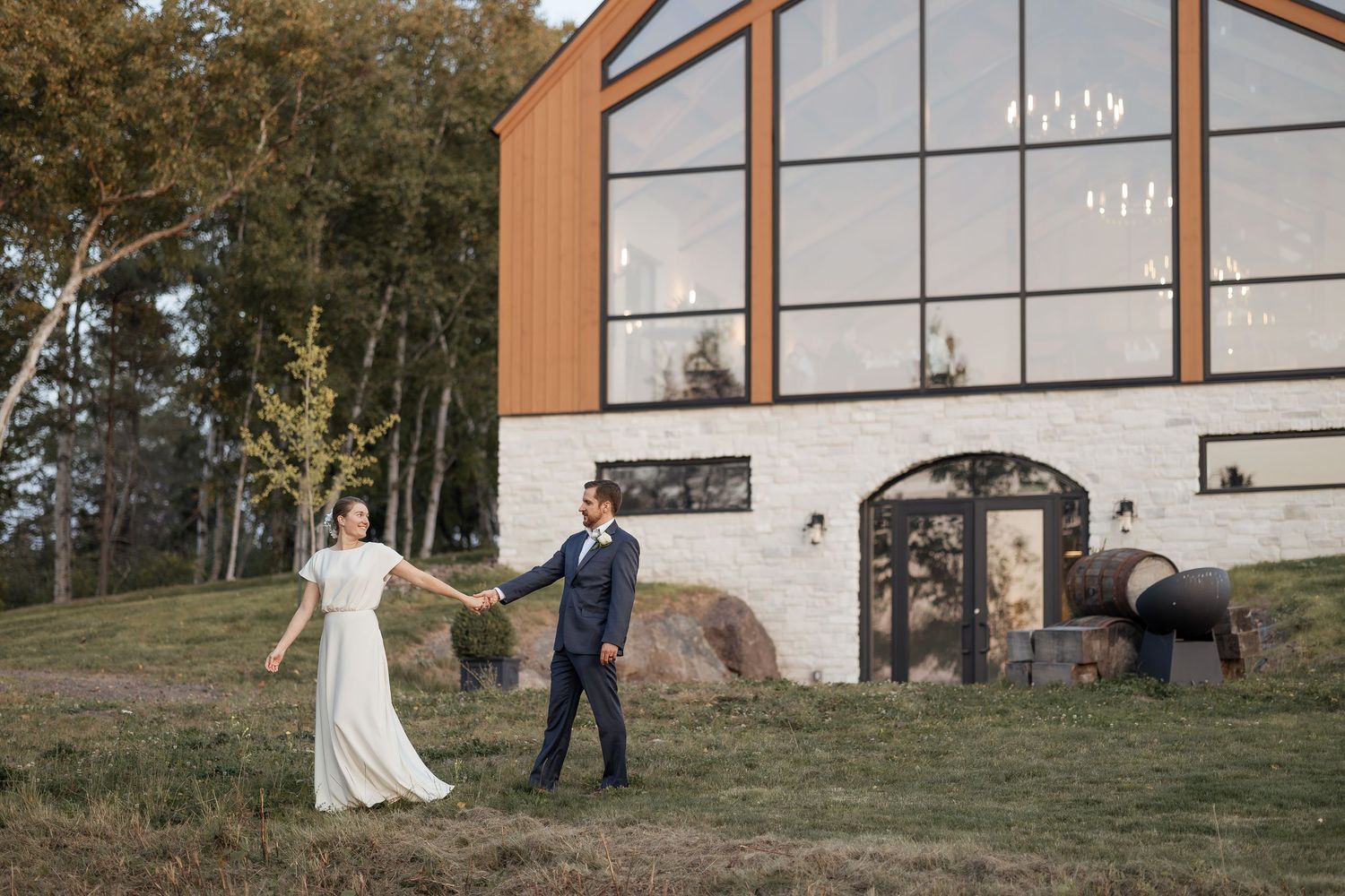 bride and groom walk hand in hand at sunset at Cidery at 51 Acres wedding photography Moncton New Brunswick photographer relaxed photos