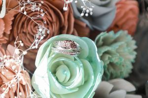 Mint green paper rose with delicate white floral accents against soft background.