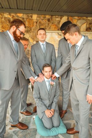 Groomsmen showing off colorful socks in a fun group photo.