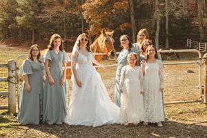 Bridesmaids in light blue dresses walking together during an autumn outdoor wedding.