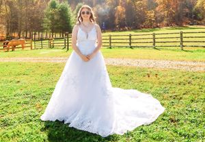 White wedding dress with long train photographed in a sunny autumn field.