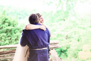 Two people sharing an embrace during outdoor wedding celebration.