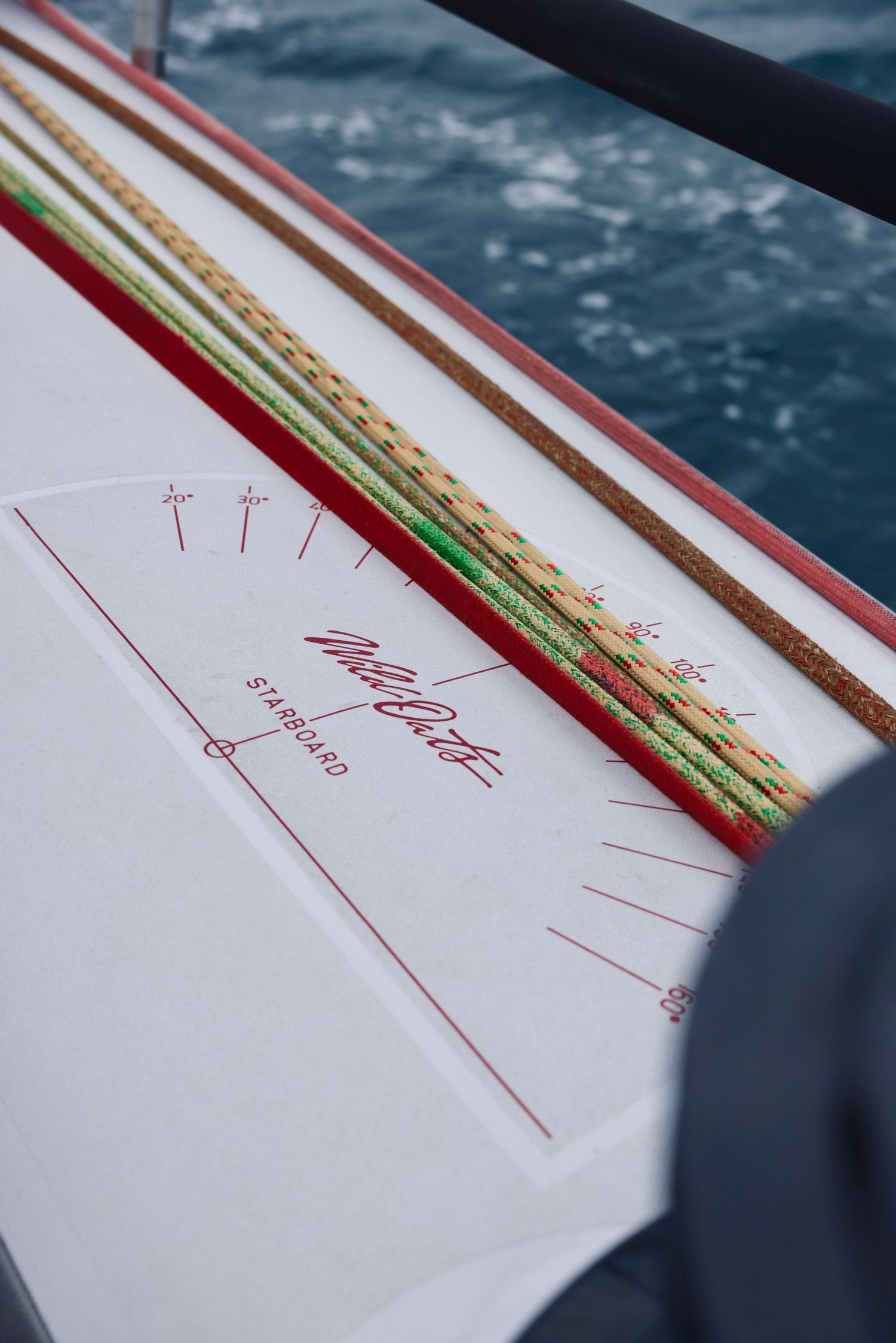 Close-up series of navigation markings on white sailboat deck.