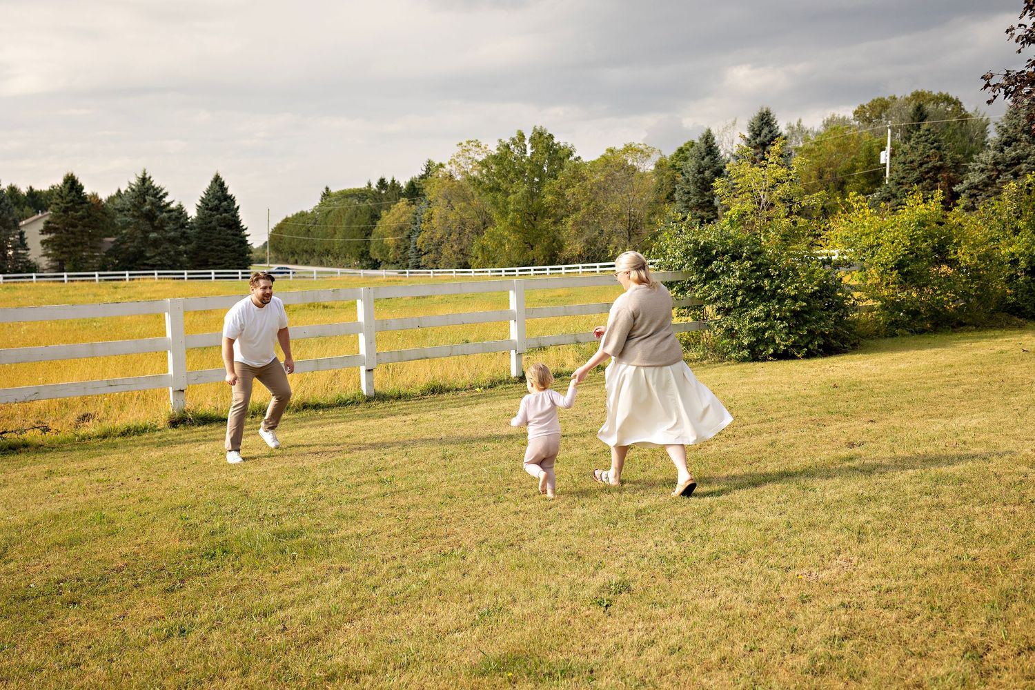 young family playing in their yard on a summer morning