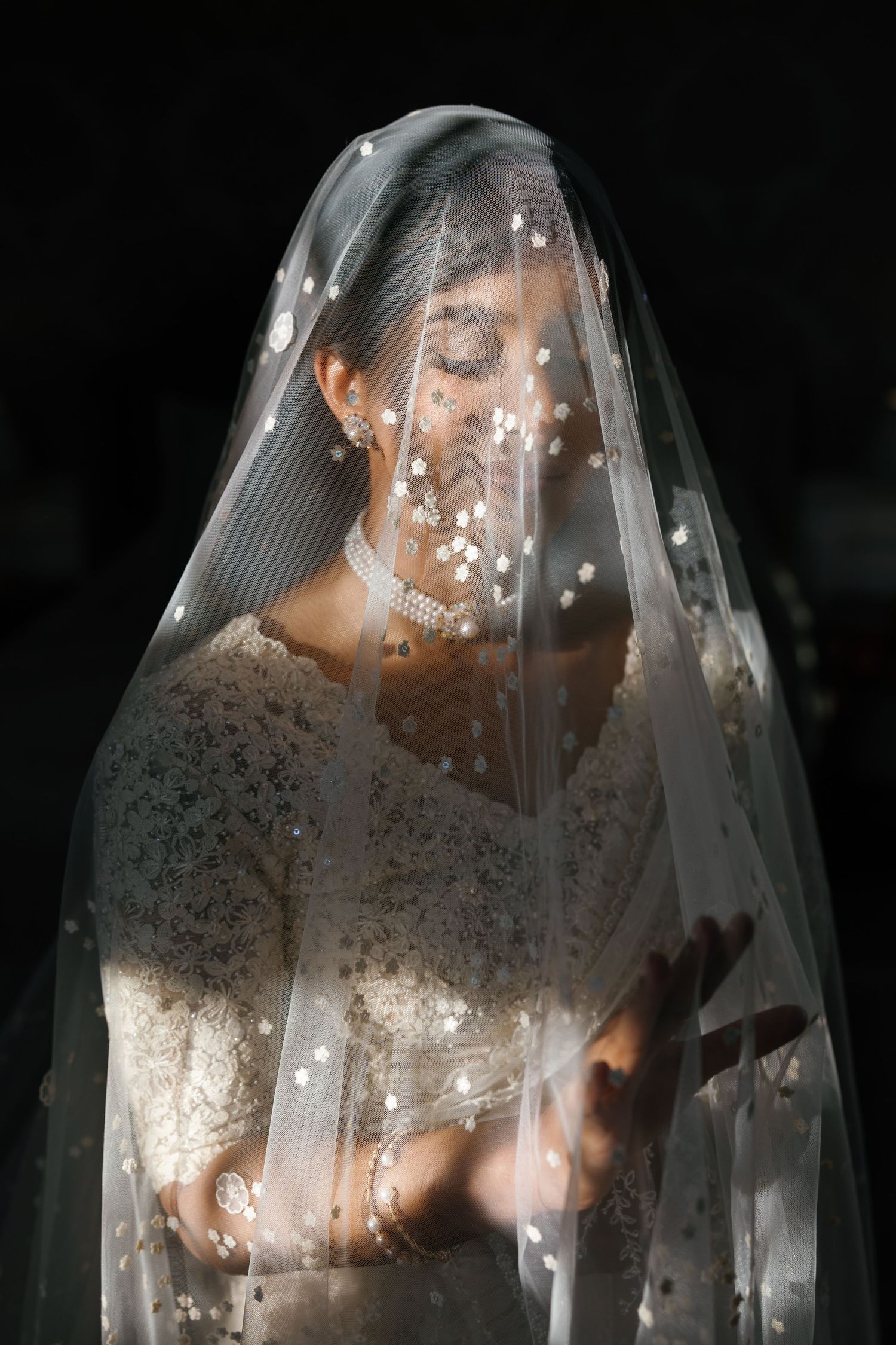 Editorial style portrait of a South Asian bride under the veil