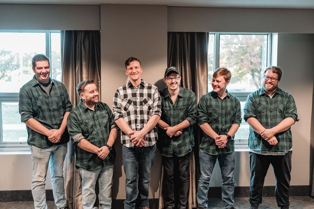 Groomsmen pose together in casual attire before the wedding ceremony.