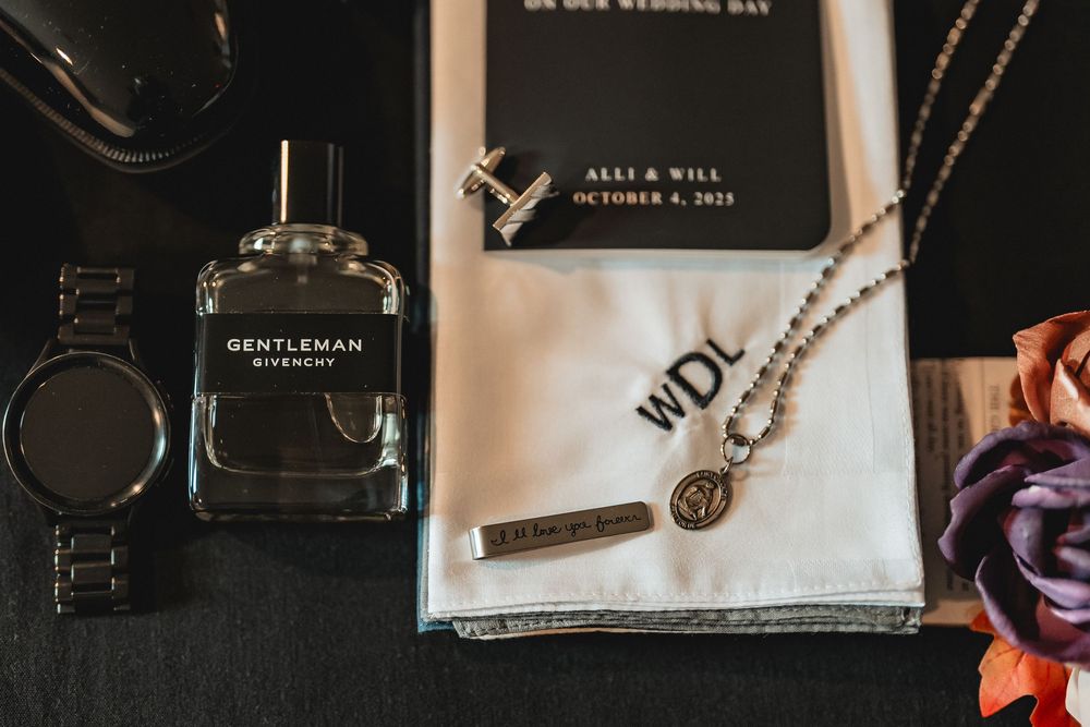 Wedding detail flatlay featuring rings, invitations, and accessories in monochrome.