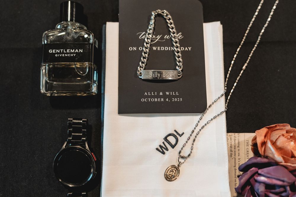 Wedding accessories and perfume bottles arranged on dark background with jewelry details.