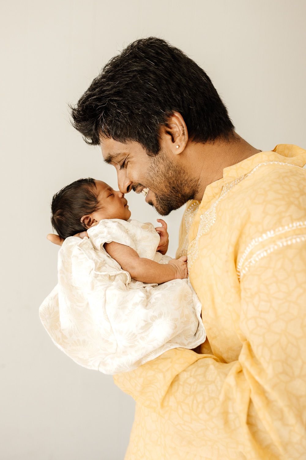 Dad snuggles newborn baby nose to nose at their in-home newborn session Bay Area