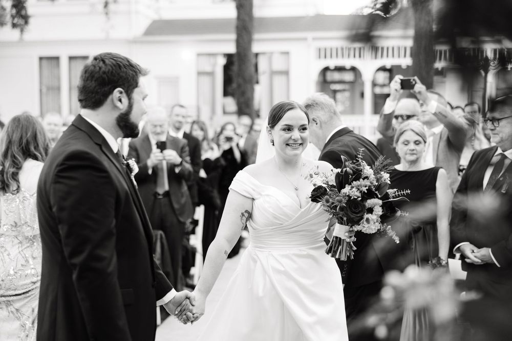 A series of candid black and white wedding photos capturing joyful moments during an outdoor celebration.