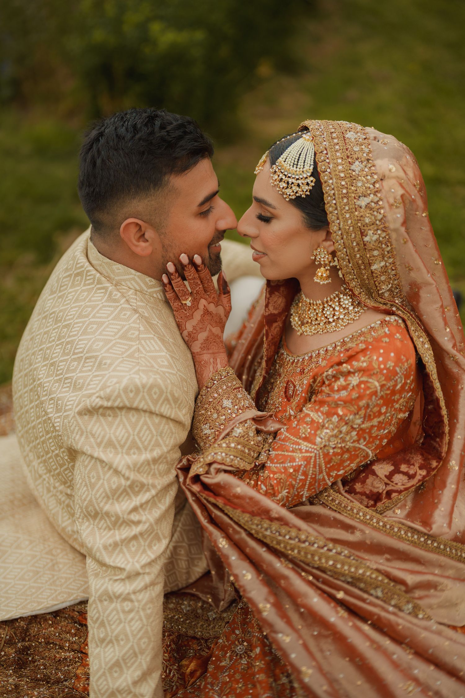 A couple in traditional South Asian wedding attire share intimate moments in a series of romantic outdoor photos.