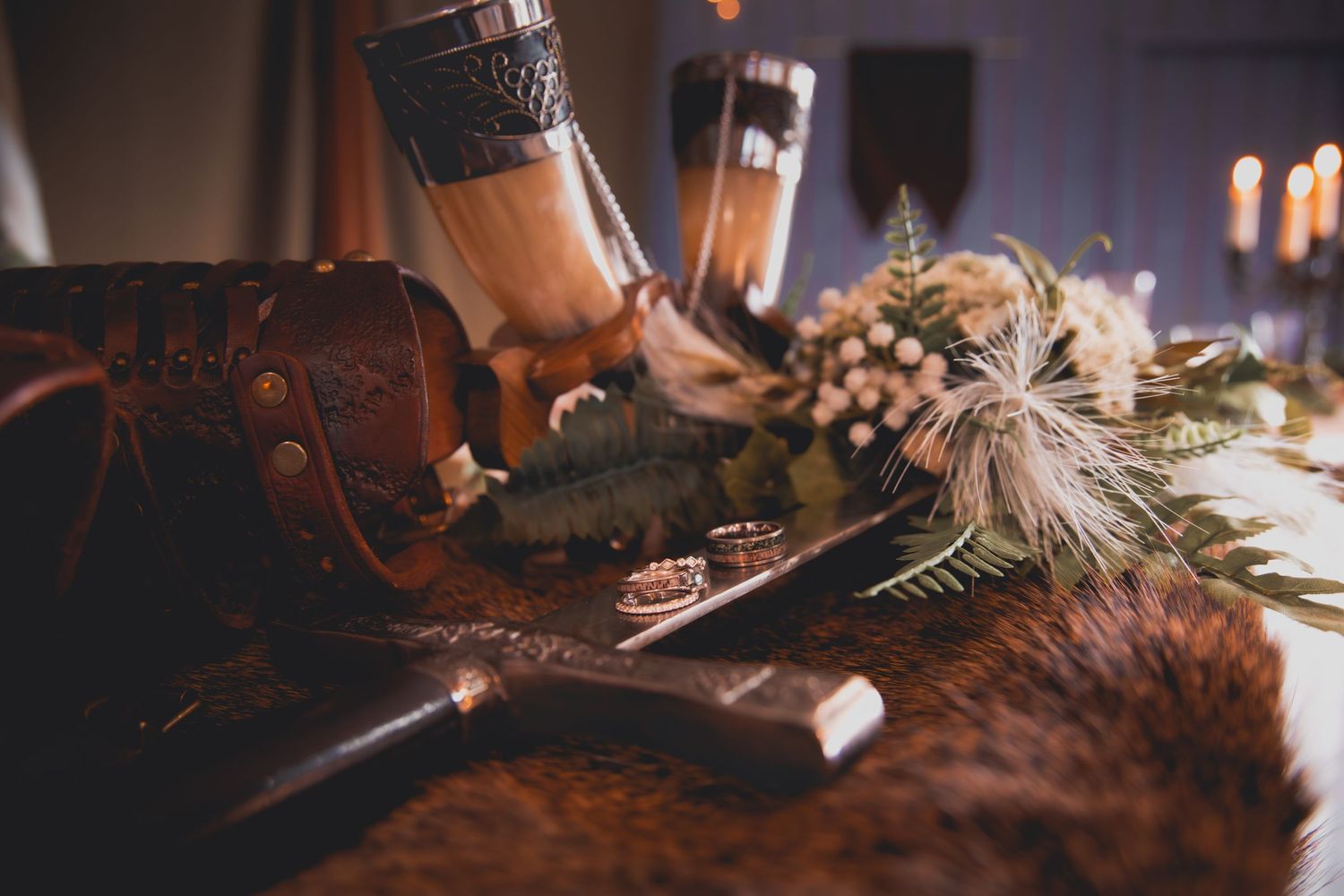 Rustic medieval feast table decorated with candles and greenery in atmospheric lighting.