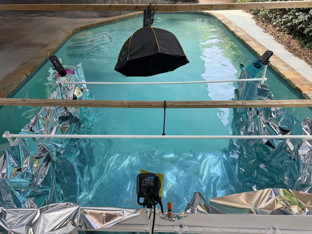 Underwater view of a swimming pool with clear blue water and reflective surface.
