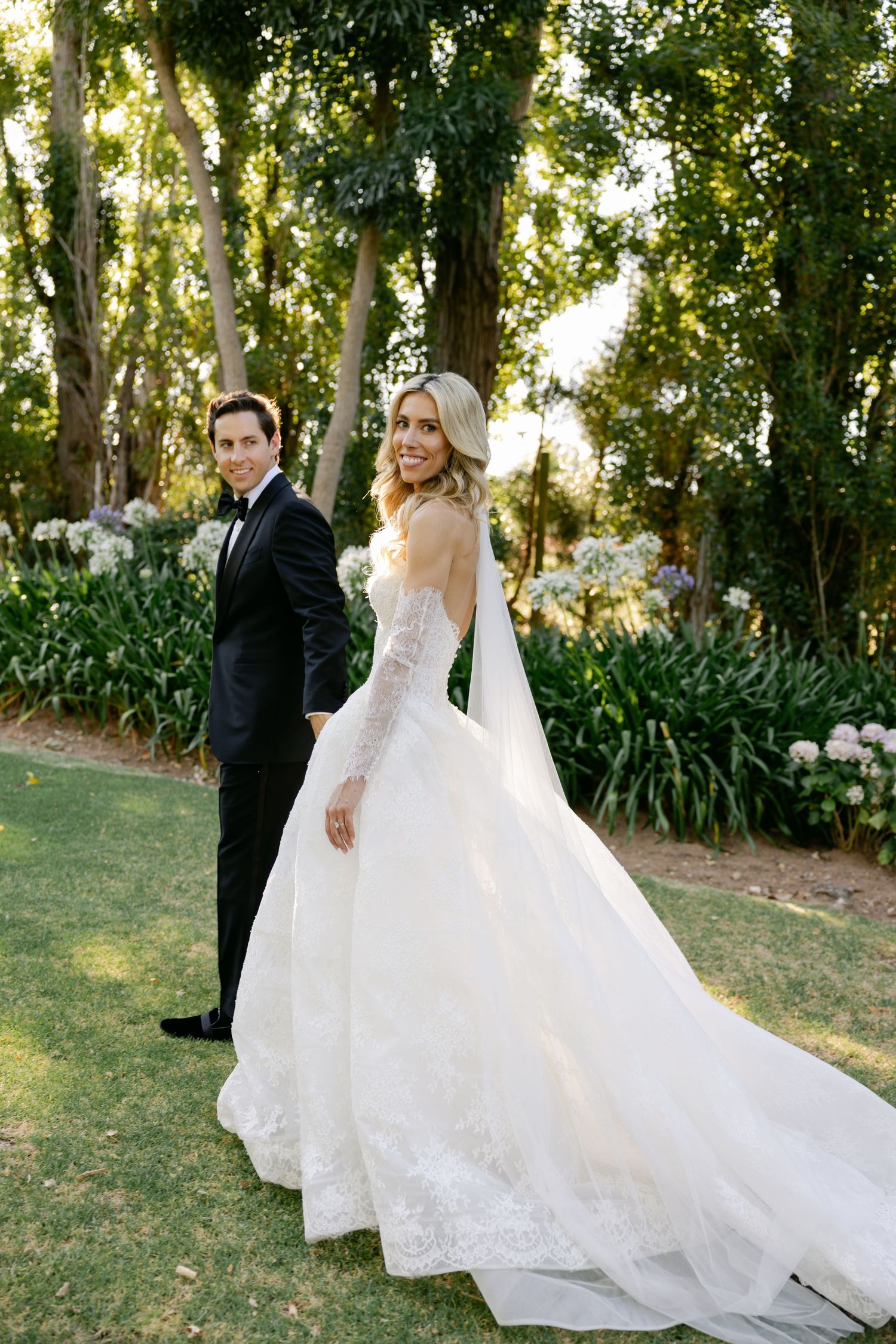 A romantic wedding photoshoot sequence showing a couple in formal attire twirling in a garden setting at sunset.