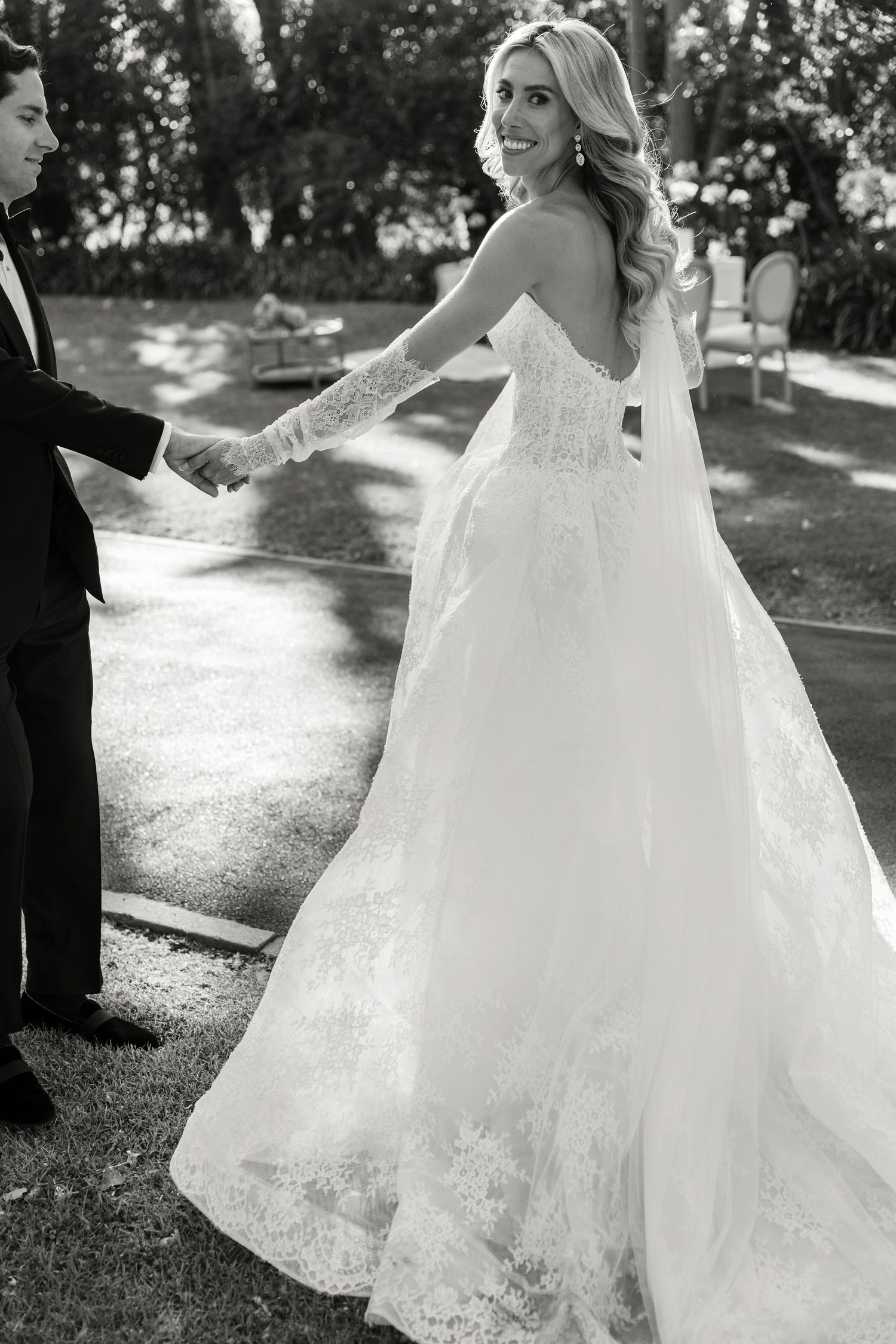 A flowing white wedding dress twirls elegantly in black and white photos showing the intricate lace details and movement.