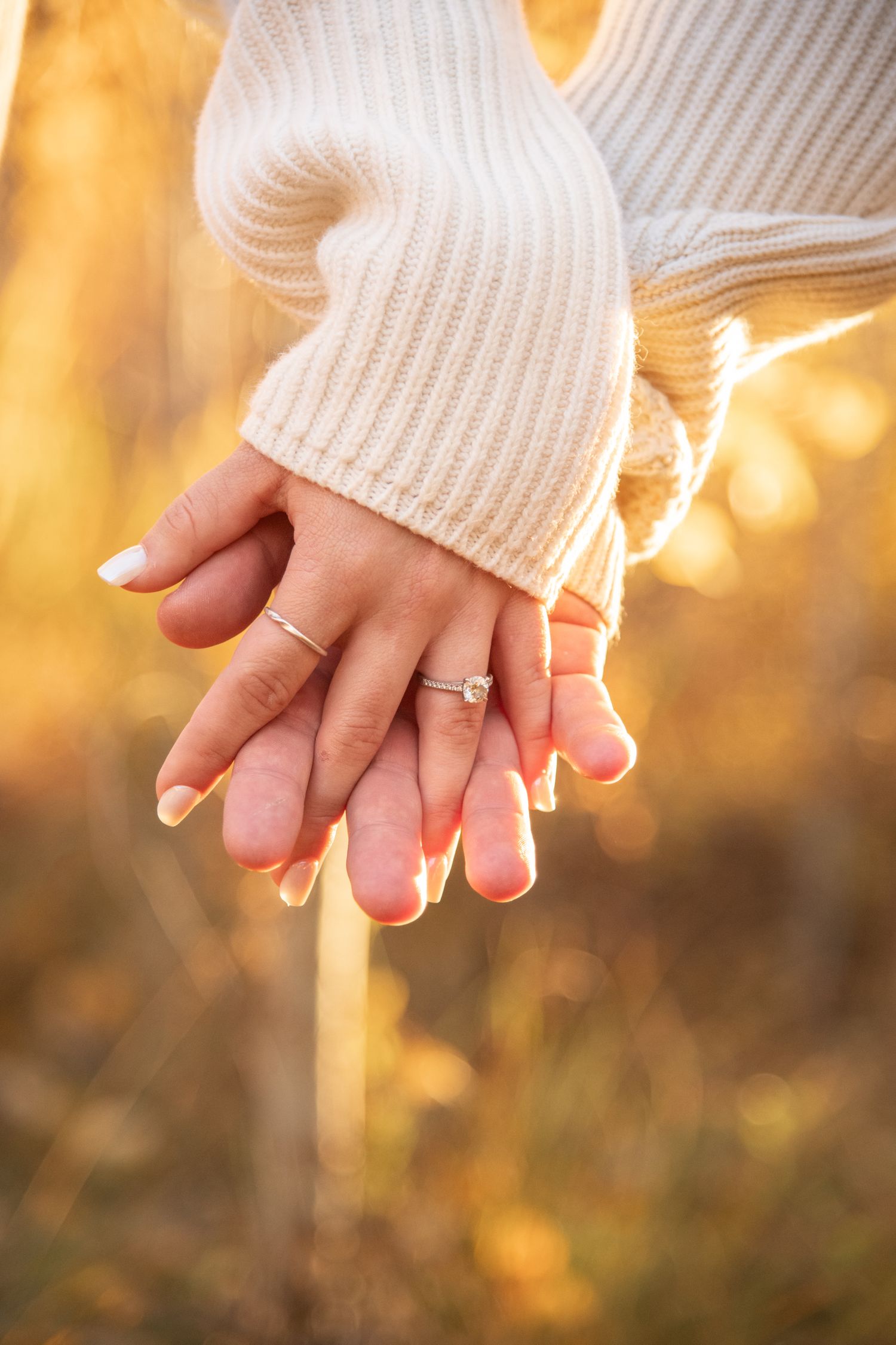 Vail fall engagement photos with couple holding hand to capture the engagement ring detail with soft fall trees and golden colors behind