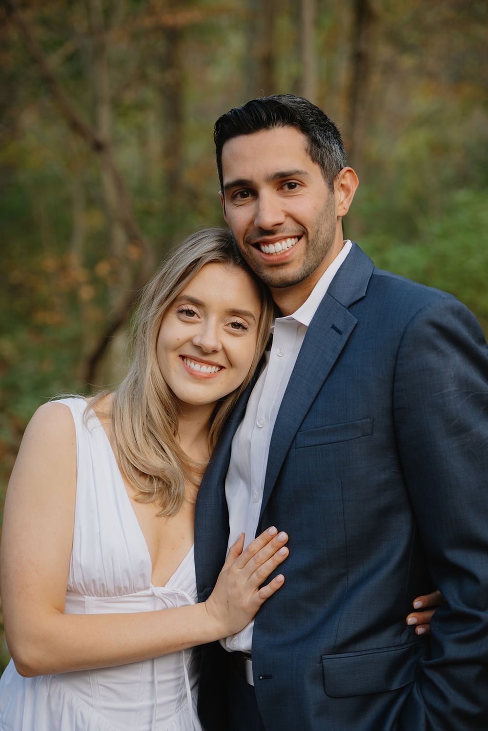 A romantic outdoor photo series showing a couple in formal attire embracing against a blurred forest backdrop.