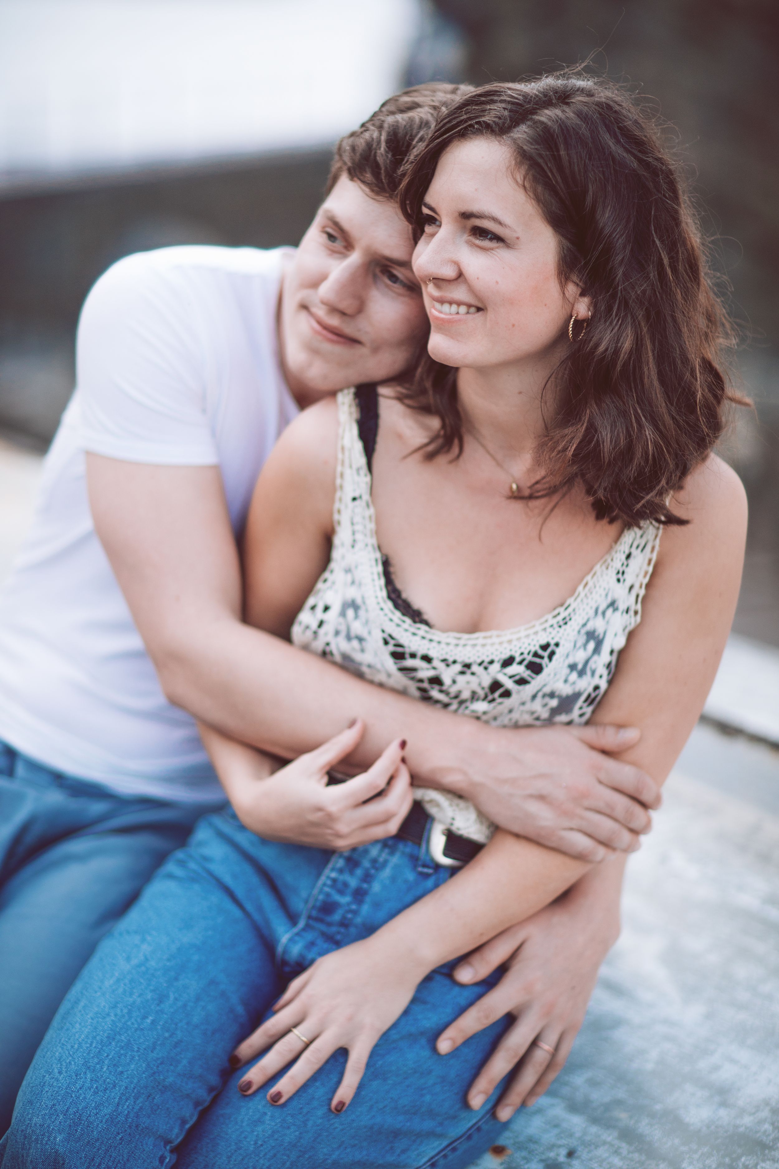 A couple shares an intimate moment while sitting together in casual clothing.