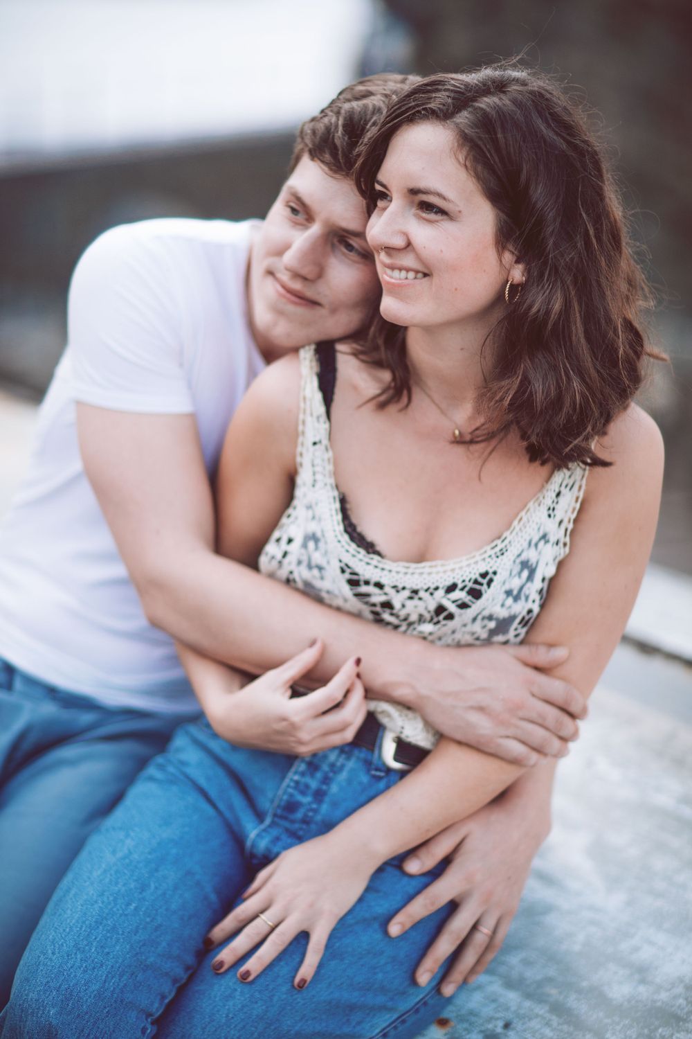 A couple shares an intimate moment while sitting together in casual clothing.
