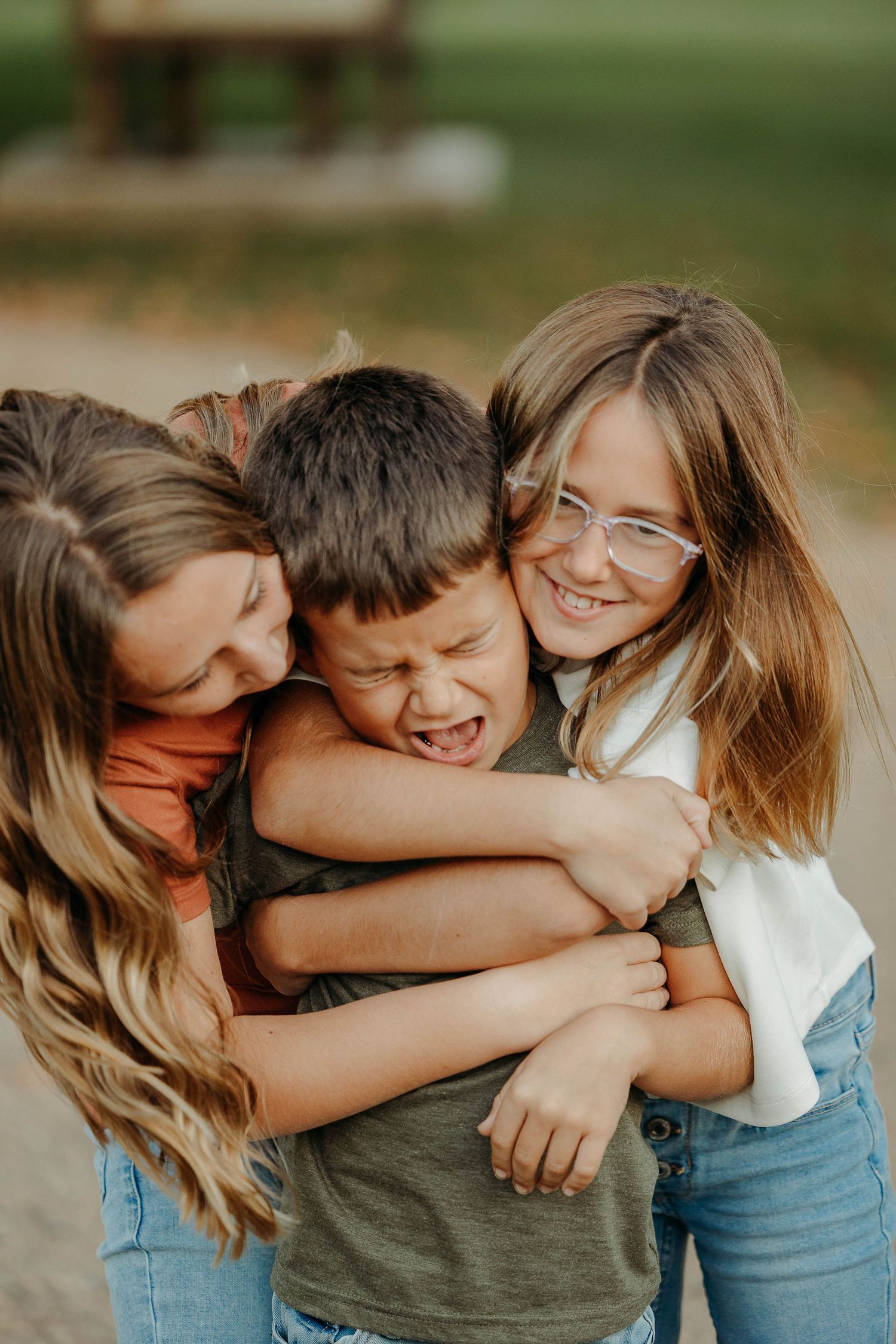 A series of candid photos showing three people embracing and laughing together outdoors.