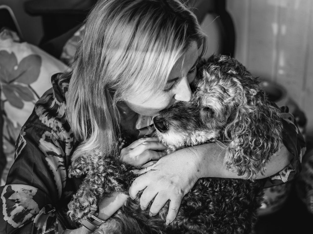 Intimate black and white photographs capture sweet moments with a fluffy pet dog.