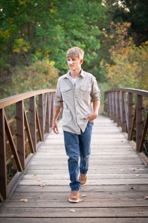 A casual stroll across a wooden bridge surrounded by autumn foliage.