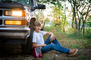 A relaxed moment leaning against vintage truck during golden hour.