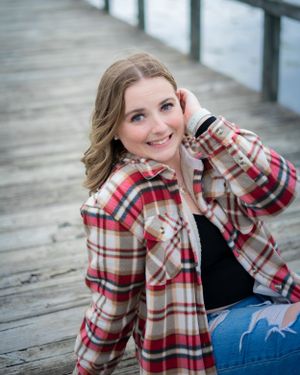 Outdoor portrait on a wooden boardwalk wearing a cozy plaid flannel shirt.