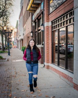 Street style photo along brick buildings and storefronts on an autumn day.