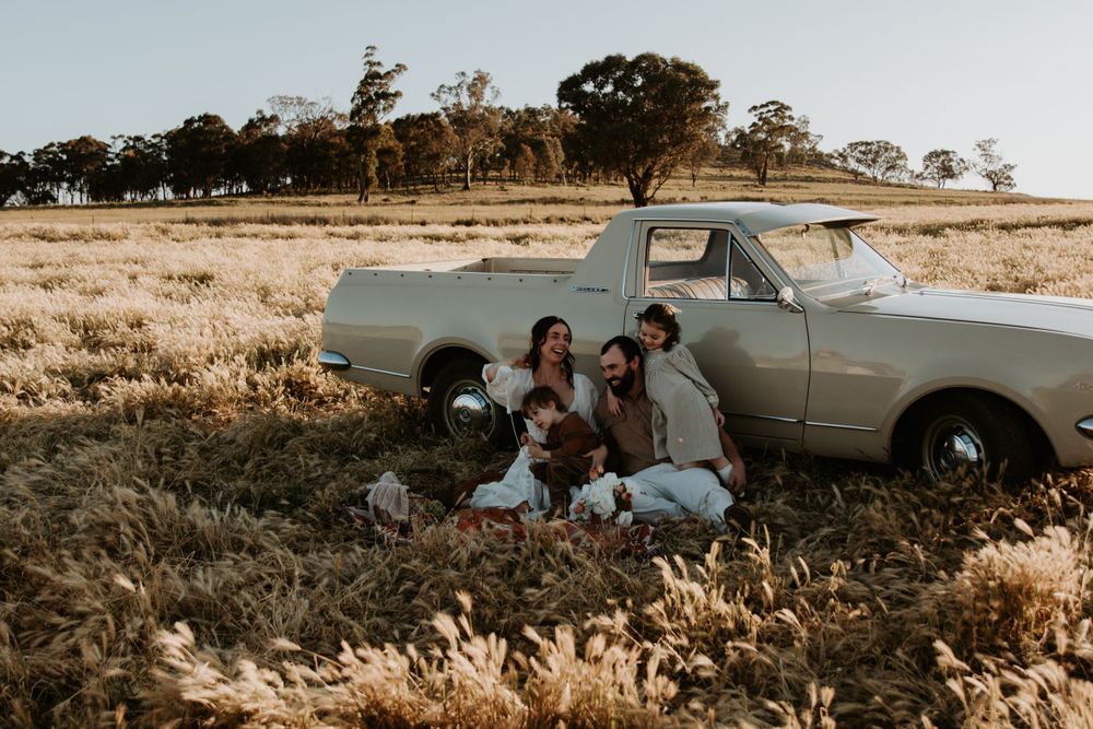 Vintage automobile photographed in golden field during sunset.