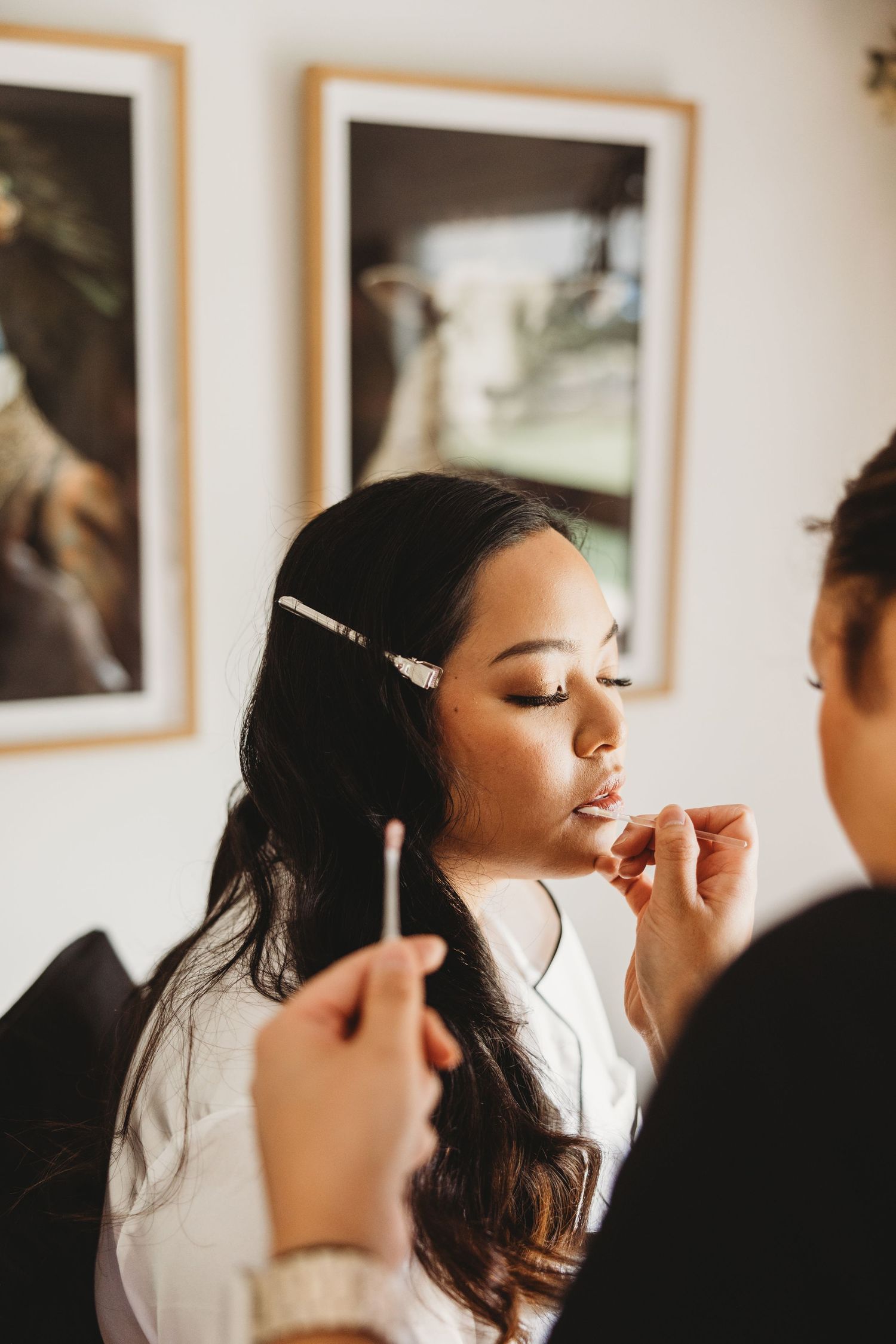 Professional makeup application in progress during wedding preparations.