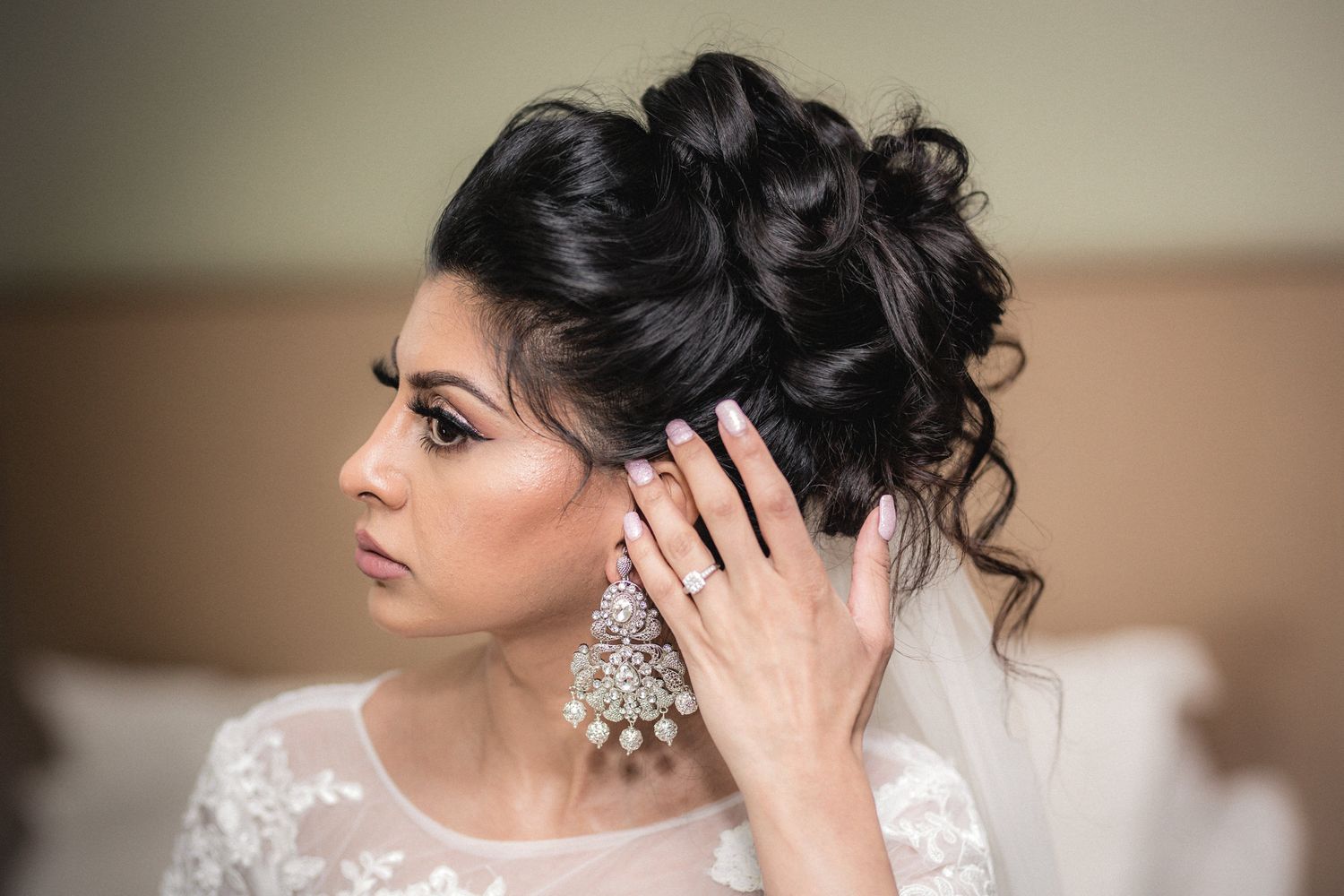 Beautiful dark haired bride outdoors in her Victorian wedding dress posing next to red foliage at Mitton Hall