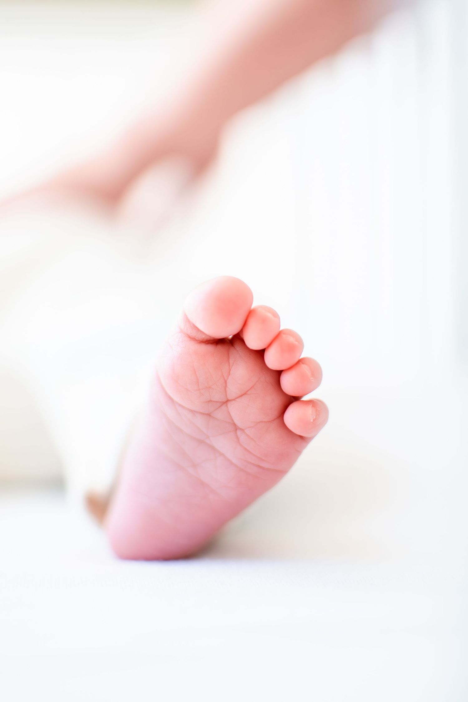 Newborn baby feet in her crib.