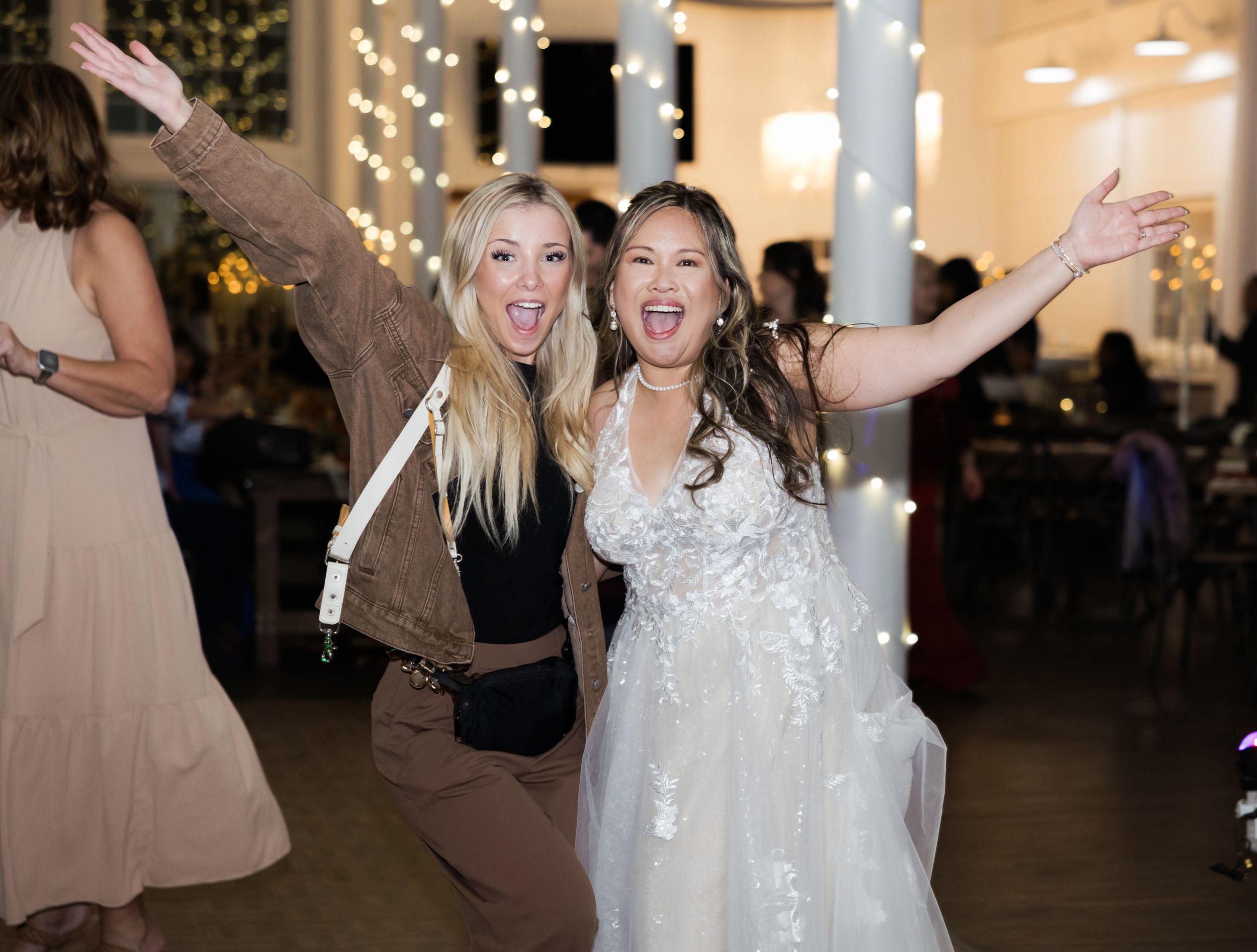 Wedding celebration with people dancing and celebrating in a decorated indoor venue.
