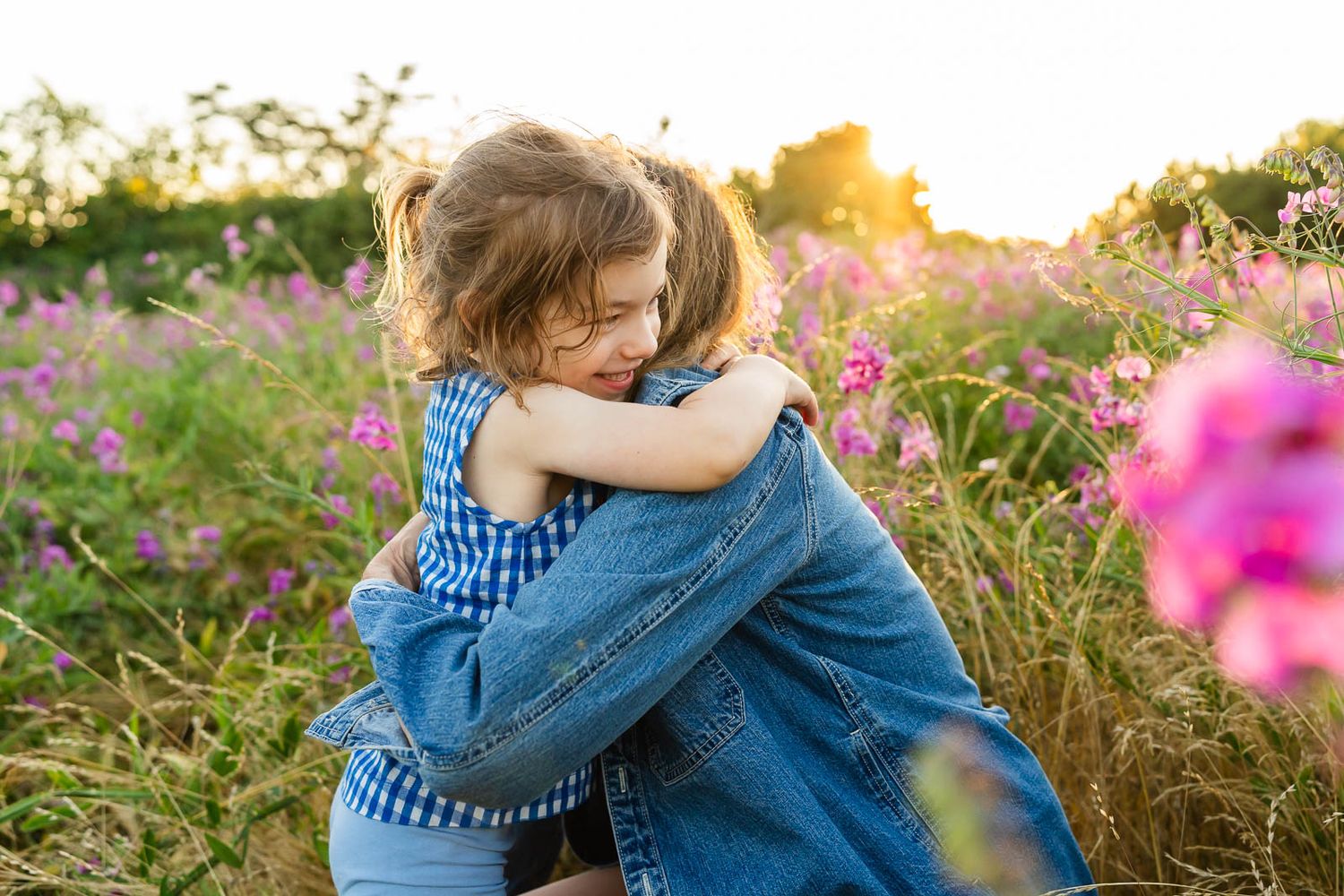 Grandmother hugs her granddaughter in a field of sweet peas in Seattle.