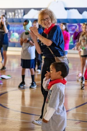 People participating in an interactive activity in a school gymnasium during an event.